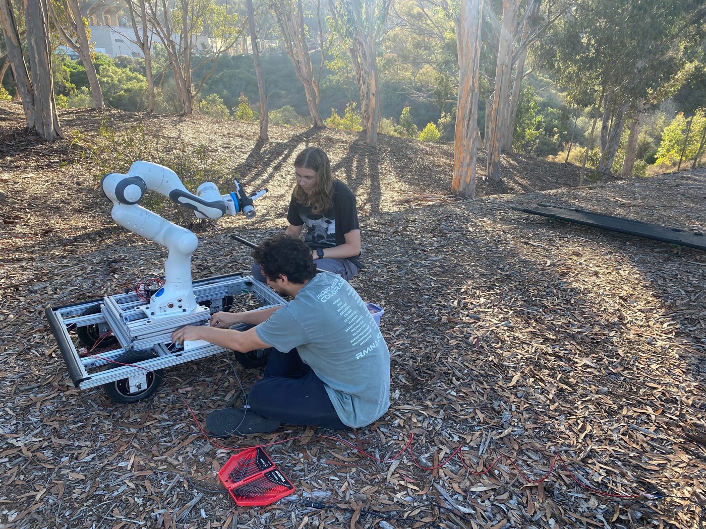 Team setting up the mobile manipulator in a eucalyptus grove